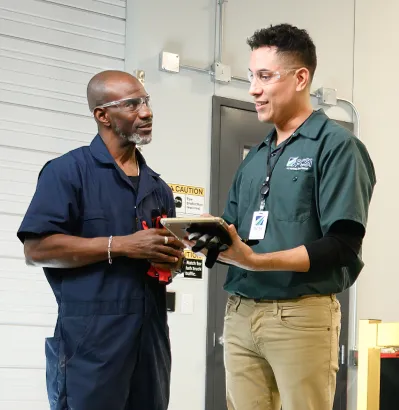 two PCSI employees chatting in a garage-like setting